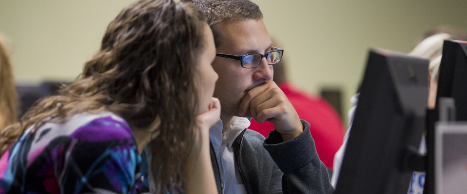 Two students studying at a computer.