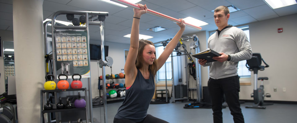 Instructor takes notes as student performs exercise.