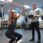 Instructor takes notes as student performs exercise.