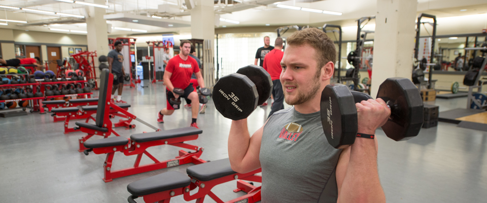 Redbird athletes lifting weights.