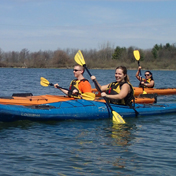 three people riding canoes