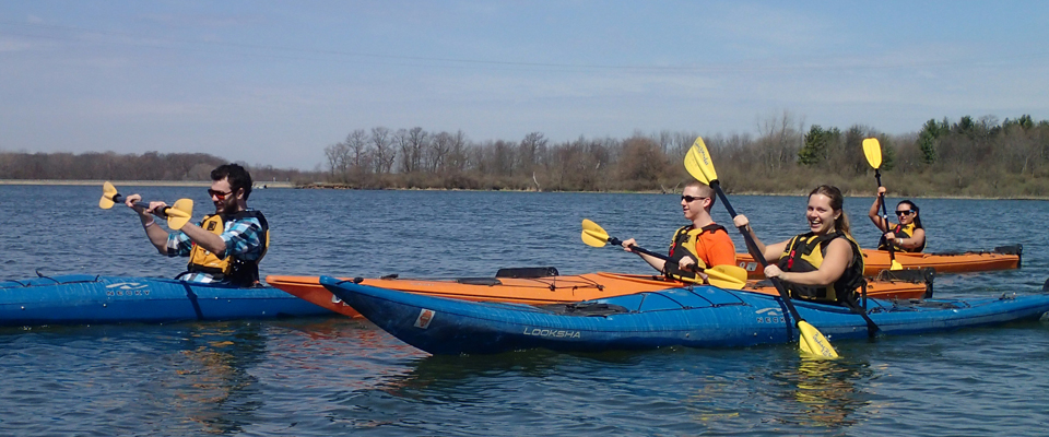 Four student kayaking in a lake.